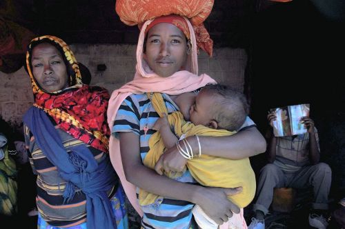 Ethiopia: Harar, Mother feeding baby on the go...