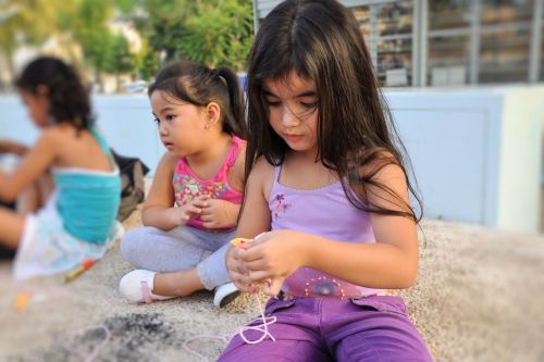 Israel: Children in Israel - Lewinsky Garden, South Tel-Aviv - Philippine girl trying to make a paper doll